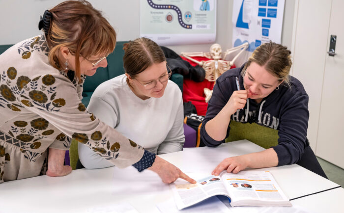 Tunti teoriaa. Lehtori Henna Lehtola (vas.) opettaa Campuskoti Merihelmen opetustilassa. Aiheena on kuoleman kohtaaminen. Sairaanhoitajaopiskelijat Janette Kokkola (oik.) ja Nette Rantanen tutustuvat kirjallisuuteen.