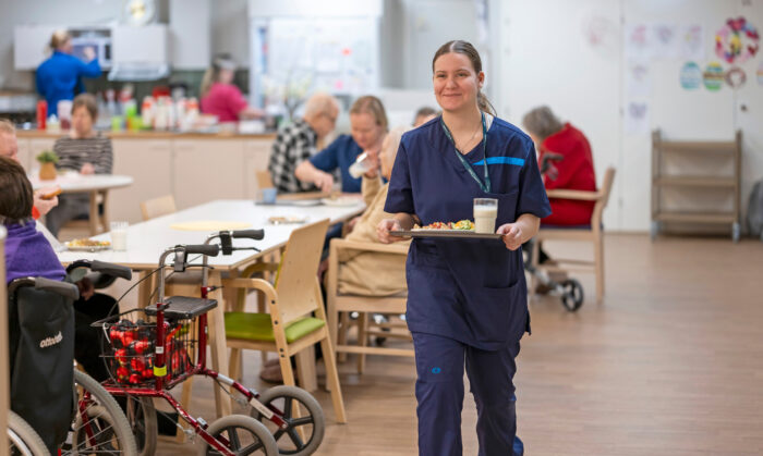 Ruokalähetys. Jenna Myllyoja vie lounaan asukkaan huoneeseen.